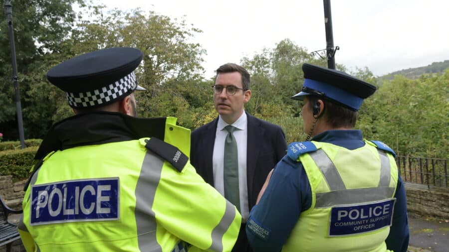 Dan Price with the back of two police officers