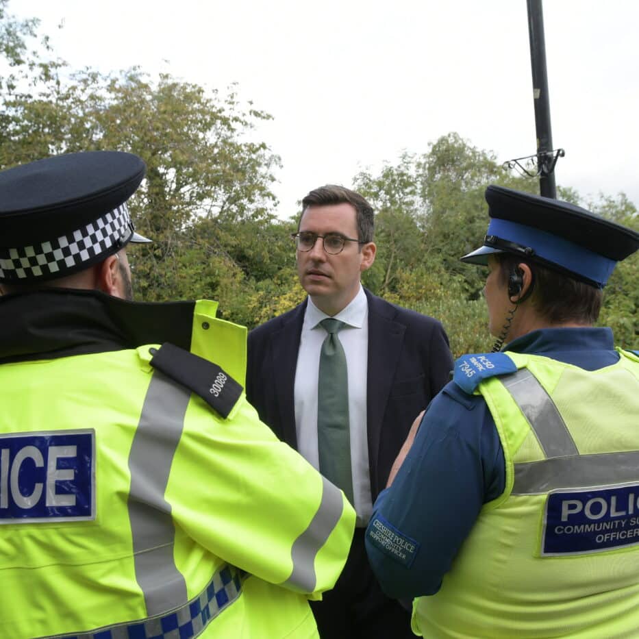 Dan Price with the back of two police officers