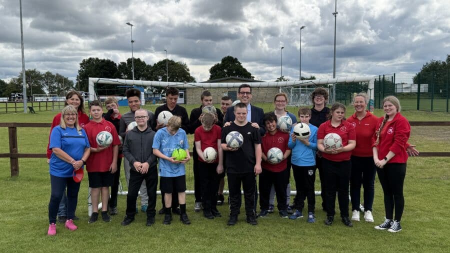 Dan Price stood on a football pitch with young people at Active Buddies - SWAP Fund