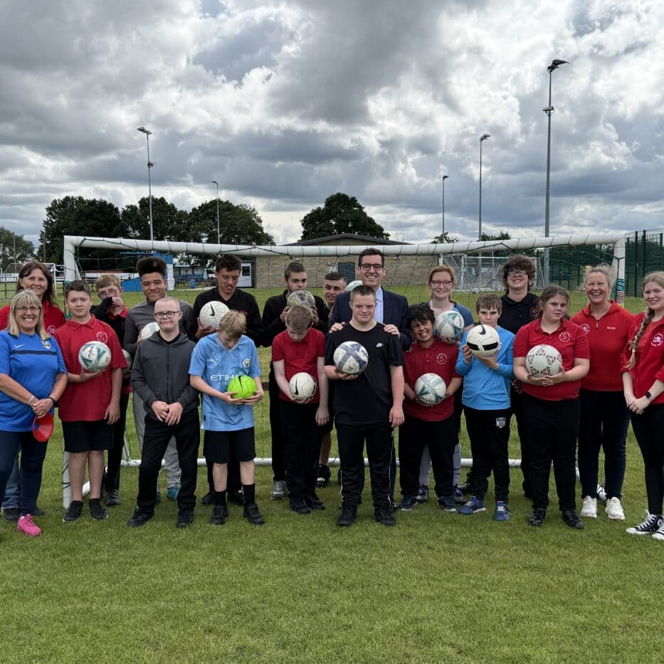 Dan Price stood on a football pitch with young people at Active Buddies - SWAP Fund