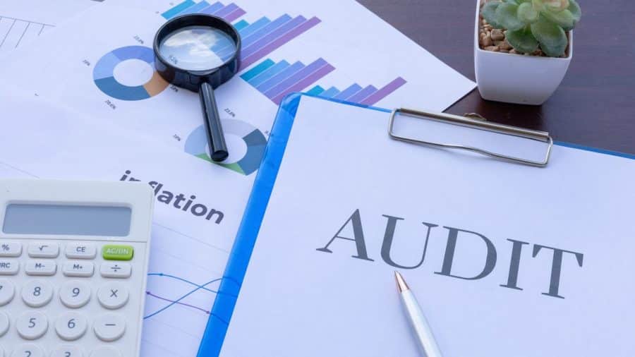 Calculator, magnifying glass and audit paperwork