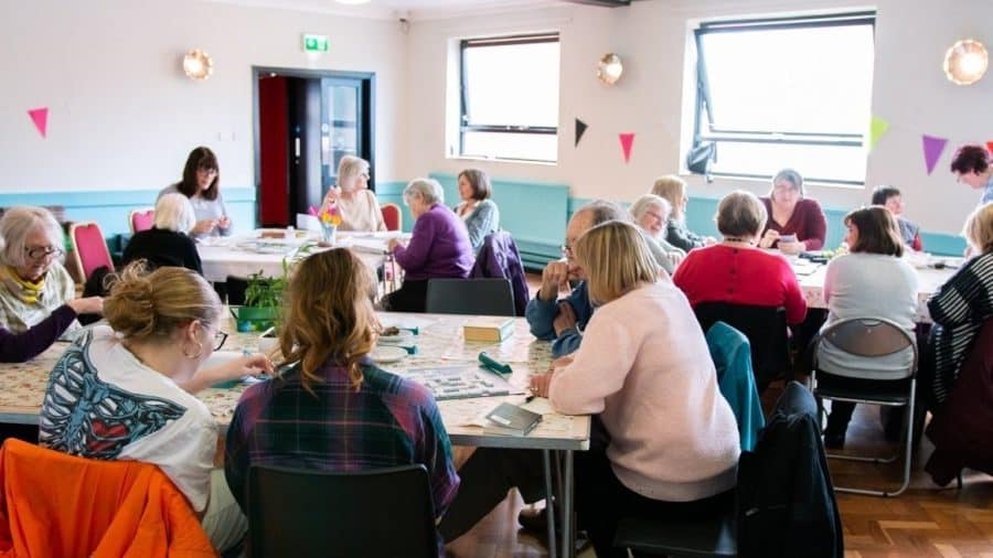 People sat around a table at a dementia cafe.