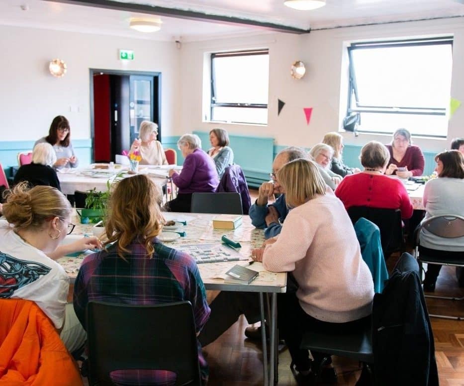 People sat around a table at a dementia cafe.